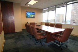 A conference room with a large table and chairs.