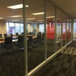 A large conference room with glass walls and carpet.