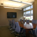 A conference room with a large table and chairs.