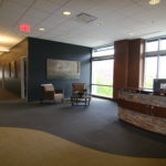 A lobby with a reception desk and chairs.