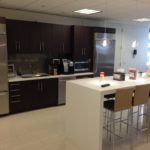 A kitchen with a large counter and stainless steel appliances.