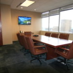 A conference room with a large table and chairs.