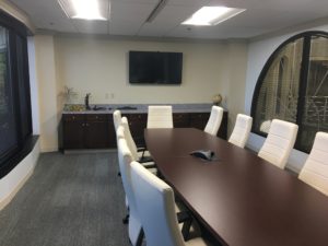 A conference room with a large table and chairs.