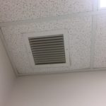 A ceiling with a vent in the middle of it