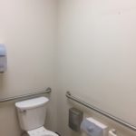 A bathroom with white walls and a toilet.