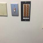 A wall with three different types of electrical outlets.