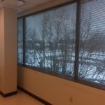 A view of trees through the window of an office.