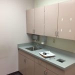 A kitchen with white cabinets and a sink.