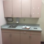 A kitchen with pink cabinets and a sink.