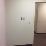 A white door and wall in an office.