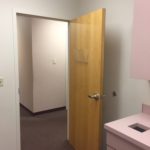 A door open to the bathroom with pink walls.