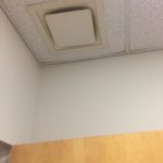 A ceiling fan in the corner of an office room.