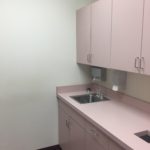 A kitchen with pink cabinets and white walls.