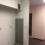 A room with a wall mounted heater and a door.