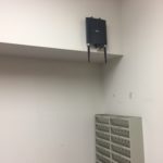 A wall mounted device is hanging on the side of a room.