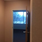 A door open to the bedroom with a view of trees.