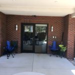 A patio with two chairs and an umbrella.