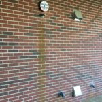 A brick wall with some clocks on it