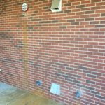 A brick wall with some air vents on it