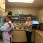 Two women in a kitchen with one holding something.