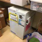 A small refrigerator sitting in the middle of a room.