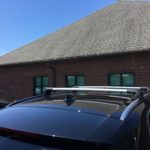 A car with the roof up and a building in the background.